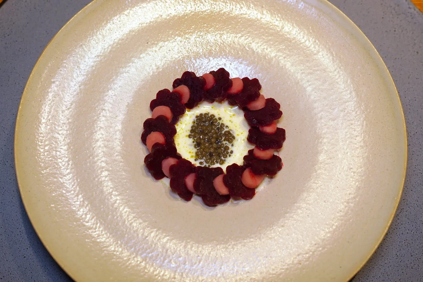BEETROOT (ADD 40 €)bear fat, caviarสุดยอดเมนู Signature Dish ที่เราแนะนำให้สั่งมาลองชิมกันดูคือคอร์สที่มีวัตถุดิบอย่างไขมันหมี เชฟเริ่มต้นโดยการนำบีทรูท 2 แบบเสิร์ฟมาในจานเดียวกัน ชิ้นสีเข้มเชฟนำไปนึ่งกับน้ำที่มีกิ่งของต้น Spruce ใส่เอาไว้ ส่วนชิ้นสีชมพูได้จากการนำบีทรูทไปดองกับ Spruce Tip Vinegar หรือน้ำส้มสายชูที่ใส่ยอดของต้น Spruce ลงไปด้วย ตรงกลางคือซอสครีมที่ผสมผสานไขมันหมีเอาไว้ด้วย จากนั้นเติมน้ำมันใบ Fig ลงไปเล็กน้อย สุดท้ายคือคาเวียร์จากฟาร์มในประเทศออสเตรียสร้างความอูมามิที่กลมกล่อมลงตัว (20/20)