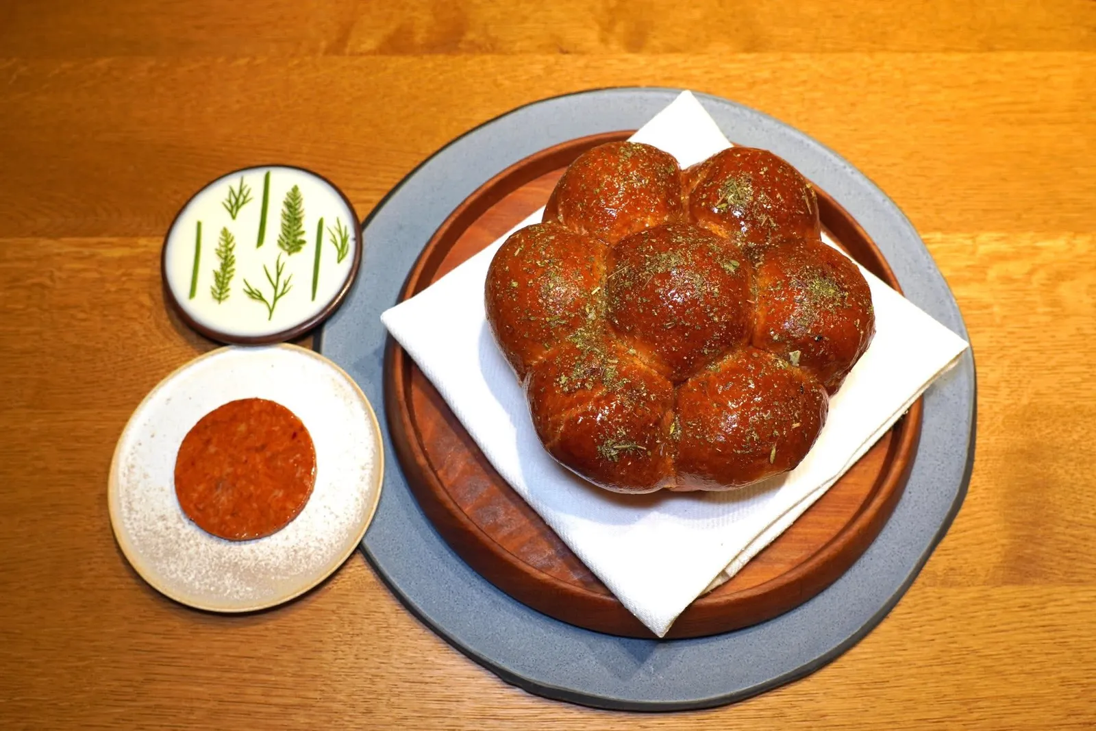 BRIOCHEwild boar, cream cheeseขนมปังที่มีส่วนผสมของเนยจืดเกือบ 50% เชฟเสริมด้วยอโรมาหอม ๆ ของน้ำมันเห็ด Porcini จากนั้นท็อปด้วยสมุนไพรจากฤดูกาลก่อน ข้าง ๆ คือกัน Nduja หรือไส้กรอกที่ทำมาจากหมูป่าท้องถิ่นจากทางตอนใต้ของประเทศสโลวีเนียผสมผสานกันกับเครื่องเทศจากฝั่งเอเชีย สุดท้ายคือครีมชีสจากฟาร์มในแถบ Škofja Loka ท็อปด้านบนด้วยใบสมุนไพรป่า