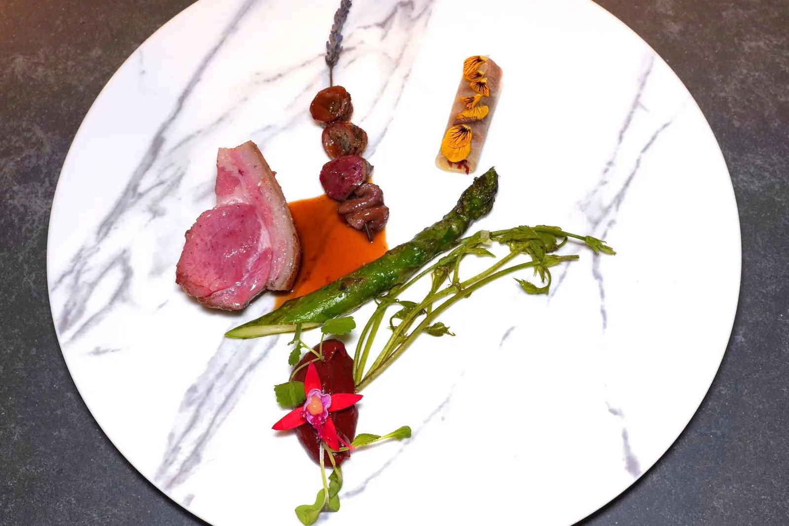 Grilled lamb from Lucanian Dolomites, Senise peppers, winter melonซี่โครงลูกแกะจากฟาร์มในประเทศอิตาลีย่างบนถ่านจนให้เนื้อสัมผัสที่นุ่มฉ่ำพ่วงมาด้วยอัตราส่วนไขมันที่สูง เชฟราดด้วย Lamb Jus เข้มข้นปานกลาง จากนั้นจับคู่รสชาติกับครีมของพริกหวาน Senise Pepper ยังมีเครื่องในลูกแกะประกอบไปด้วยหัวใจ ตับ สวีทเบรด และชิ้น Fillet เสียบไม้ย่างมาอย่างดี ข้าง ๆ กันคือหน่อไม้ฝรั่งเขียวท้องถิ่นของอิตาลีโดยเชฟคัดเลือกผักคุณภาพสูงมาย่าง ยังมี Winter Melon Canele สอดไส้พริกไทย Senise เสิร์ฟมาในสไตล์ In Saor ซึ่งมีต้นกำเนิดอยู่ในแถบนคร Venice เตรียมขึ้นโดยผสมผสานไวน์แดง น้ำส้มสายชู และถั่วลิสง ยังมีองค์ประกอบอื่น ๆ เช่นเฟนเนลและองุ่นอยู่ด้วย (16/20)