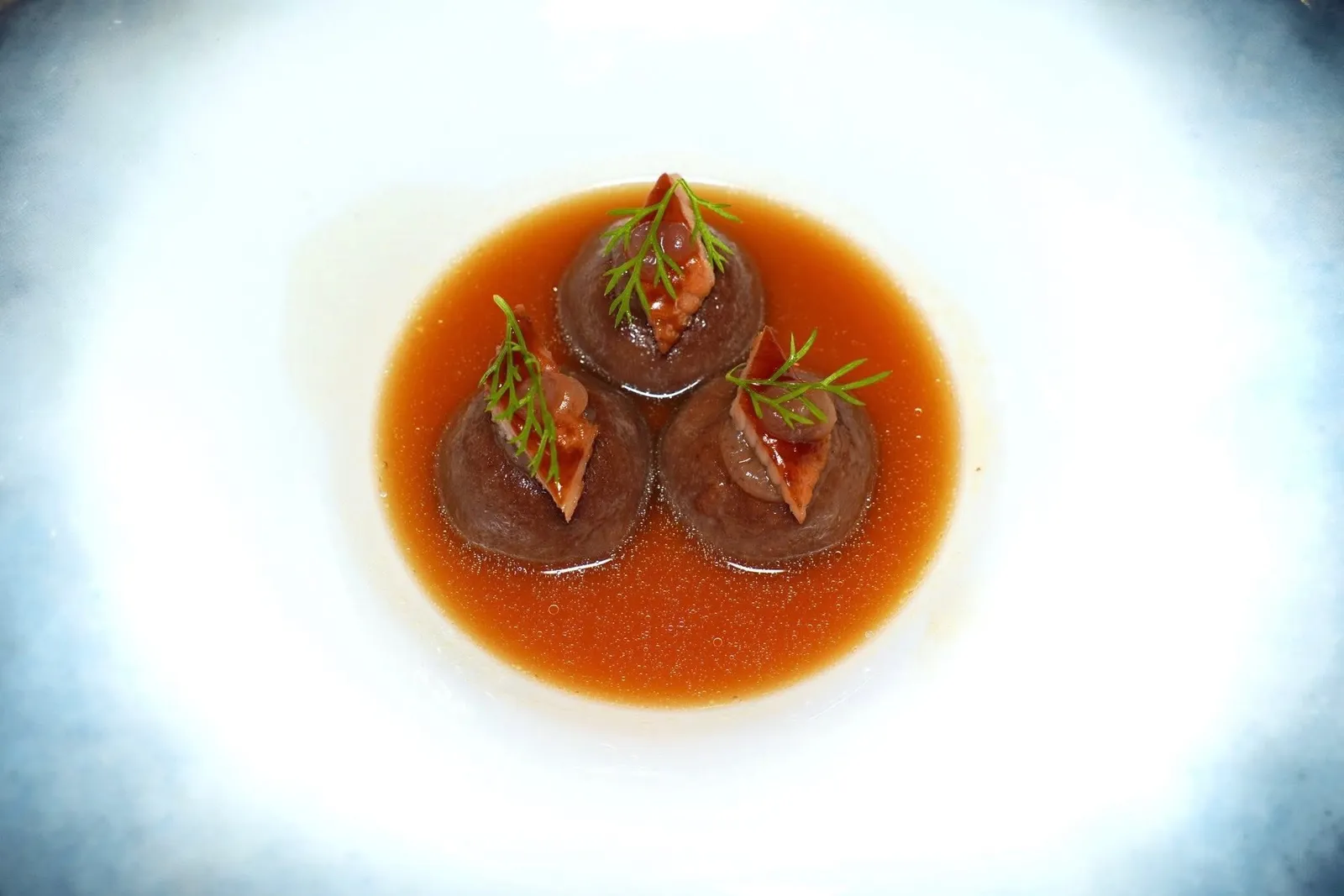 Mushrooms ravioli, smoked eel, citrus scented chicken consomméราวิโอลีสอดไส้เห็ดเนื้อเนียน ด้านบนท็อปด้วยเจลของ Anise รวมไปถึงชิ้นปลาไหลรมควันและใบ Fennel ป่า จากนั้นเชฟจะเทราดซุป Consommé ไก่รสชาติเบาโดยเชฟใส่อโรมาของเลมอนลงไปด้วย อย่างไรก็ตามในแง่ของเนื้อสัมผัสจากแต่ละองค์ประกอบในจานพบว่ากลืนกันไปจนเกือบหมด (16/20)