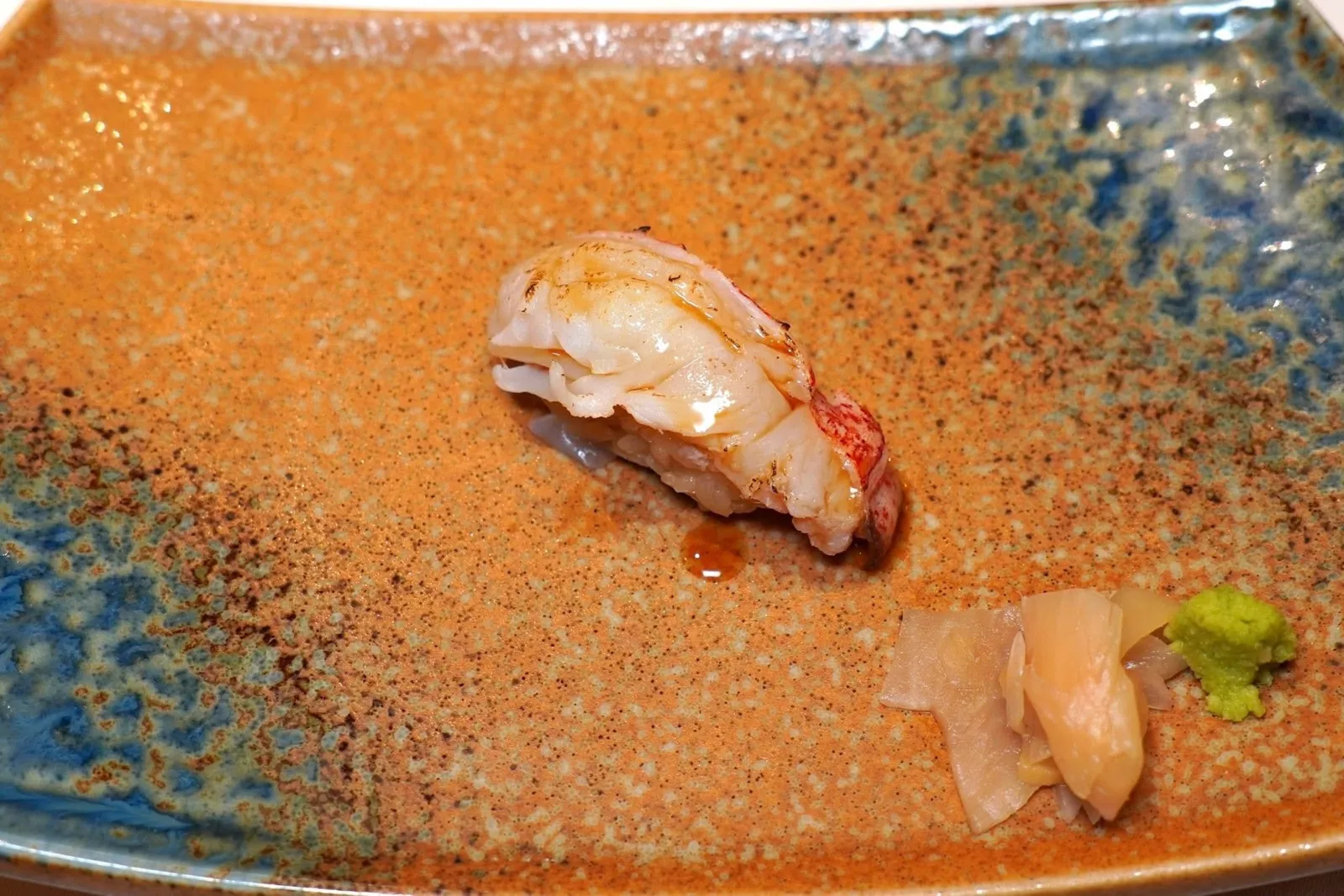 LOBSTER ABURIBlow-torched lobster, shoyu butter riceกุ้งล็อบสเตอร์ที่เชฟนำมาทอร์ชด้วยไฟด้านเดียวจนหอม เสิร์ฟมาบนชิ้นข้าวซูชิผสมเนยและวาซาบิ
