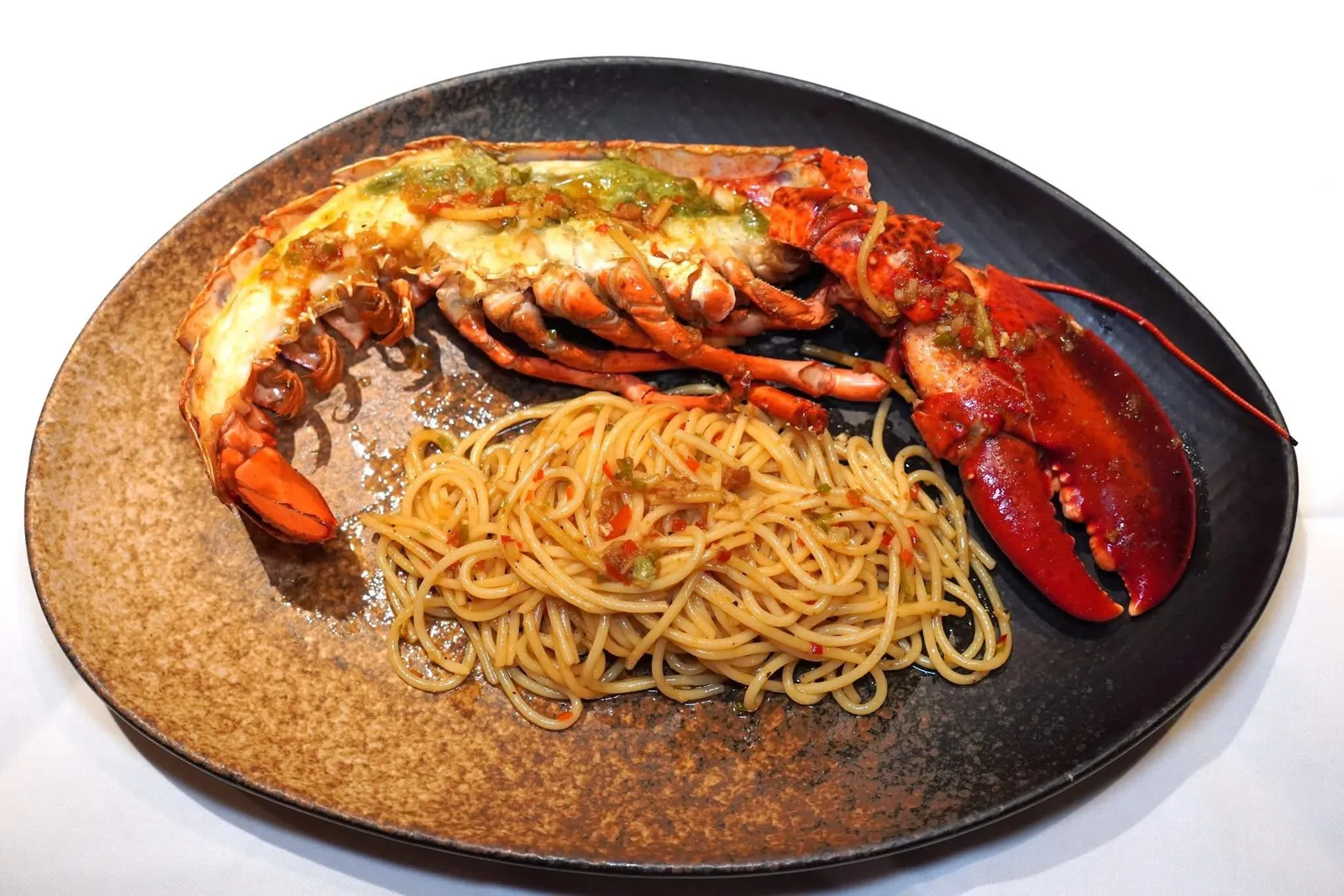 GRILLED LOBSTER AGLIO E OLIO (1,250++)Half lobster, extra virgin olive oil, garlic, lobster reductionกุ้งล็อบสเตอร์ครึ่งตัวเสิร์ฟมากับพาสต้าเส้นสปาเก็ตตี้คลุกเคล้ากับน้ำมันมะกอก พริก กระเทียม และซอสกุ้งล็อบสเตอร์เคี่ยวจนงวด