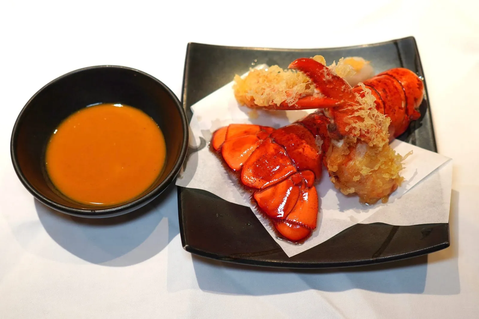 LOBSTER TEMPURACrispy lobster tail, seasonal vegetables, grated radish, ginger, lobster tempura sauceกุ้งล็อบสเตอร์ชุบแป้งทอดสไตล์เทมปุระ เนื้อกุ้งหวานตัดกันกับความกรอบมันของแป้ง เชฟแนะนำให้จิ้มลงในซอสที่มีความคล้ายคลึงกับล็อบสเตอร์บิสก์