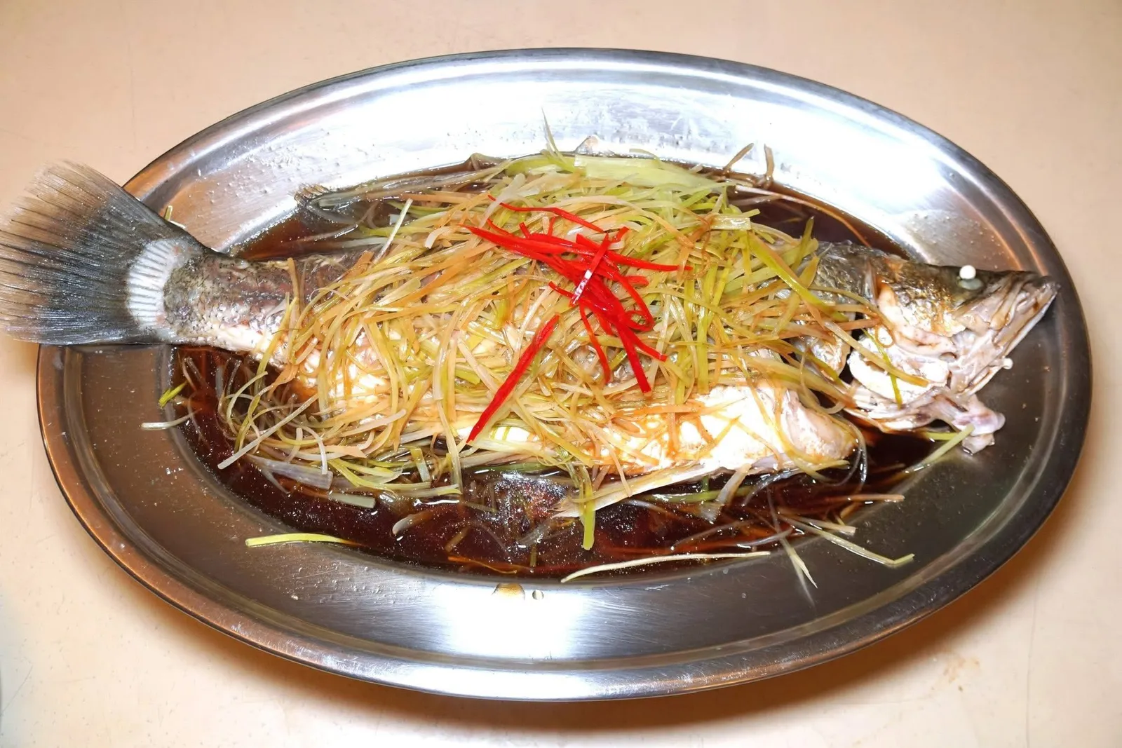 หอยลายผัดพริกเผา (เล็ก) (200)ปลากะพงนึ่งซีอิ๊ว (700)STEAMED SEABASS WITH SOY SAUCEปลากะพงเป็น ๆ ว่ายน้ำอยู่ในตู้หน้าร้าน ทางร้านนำไปนึ่งกับซีอิ๊วได้สุกพอเหมาะ เนื้อปลานุ่มจนเกือบละลายในปาก รสชาริของซีอิ๊วเค็มนำเบา ๆ (13/20)