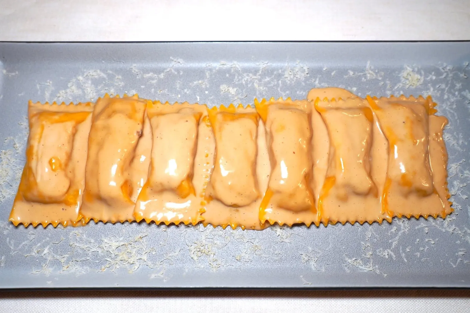 RAVIOLO STUFFED WITH GUINEA FOWL AND HAZELNUTS IGP SAUCE (18 €)ราวิโอโลชิ้นโตทรงสี่เหลี่ยมผืนผ้า ด้านในยัดไส้เนื้อไก่ต๊อกเสริมด้วยชาติของชีส Bra Tenero จากนั้นราดด้วยซอสถั่วฮาเซลนัทรสชาติหวานละมุน (15/20)