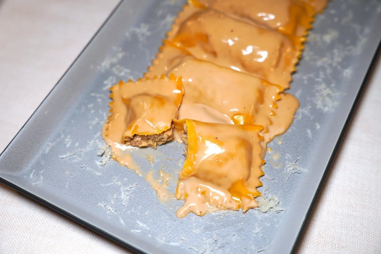 RAVIOLO STUFFED WITH GUINEA FOWL AND HAZELNUTS IGP SAUCE (18 €)ราวิโอโลชิ้นโตทรงสี่เหลี่ยมผืนผ้า ด้านในยัดไส้เนื้อไก่ต๊อกเสริมด้วยชาติของชีส Bra Tenero จากนั้นราดด้วยซอสถั่วฮาเซลนัทรสชาติหวานละมุน (15/20)