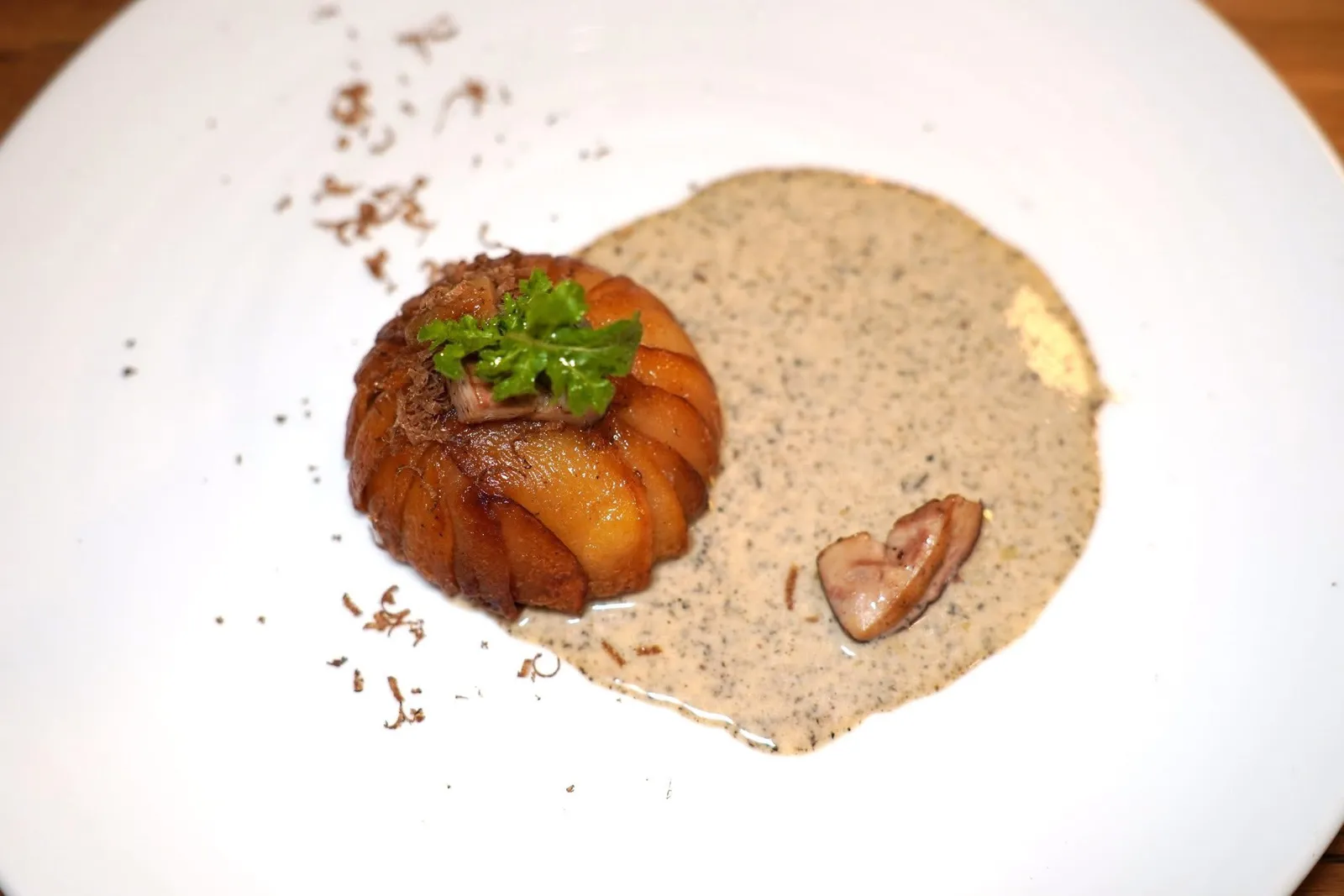 Un petit gâteau de pommes de terre aux cèpes. jus de truffes.มันฝรั่งจากภูเขาทาวตอนใต้ของประเทศอิตาลีเสิร์ฟมาเป็นเค้กควบคู่ไปกับเห็ดพอร์ชินีป่าท้องถิ่น ด้านบนท็อปด้วยกระเทียมสีชมพูที่ผ่านการอบด้วยอุณหภูมิไม่สูงนักในเตาอบจนได้เนื้อสัมผัสที่น่าพึงพอใจ ส่วนตัวซอสเตรียมมาจากทรัฟเฟิล พอร์ชินี และครีม (17/20)