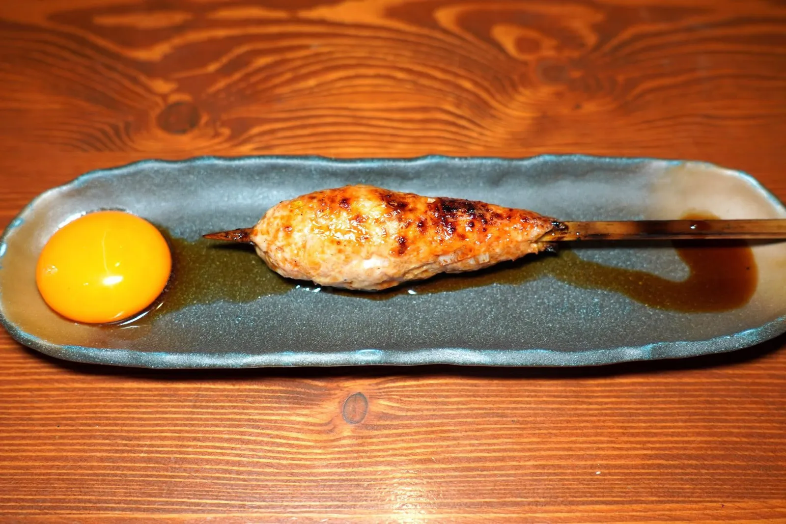 Tsukune (100++)Ground chicken meat with teriyaki sauceซึคุเนะหรือน่องไก่สับปั้นเป็นก้อนรีแบบลูกชิ้นย่างด้วยถ่านบินโจจนสุกแบบทั่วถึง วิธีชิมให้จิ้มลงในไข่แดงดิบคลุกเคล้ากับซอสเทอริยากิ (14/20)