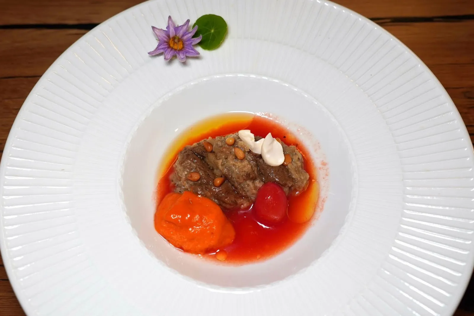 Une compotée d'aubergines, eau végétale de tomates Datterino.มะเขืออบที่เตรียมมาเป็นกอมโปตนุ่มละมุนลิ้นในสไตล์ Eggplant Napoletana ทั้งยังมีความหอมของกระเทียมอยู่ด้วย รอบ ๆ คือซุปใสที่มีความเปรี้ยวอุมามิของมะเขือเทศ Datterino ผสมผสานกับน้ำมันมะกอกเล็กน้อยและใบเบซิล ด้านบนคือเมล็ดถั่วอัลมอนด์สดและเมล็ดสนอบ นอกจากนี้ยังมีมูสมะเขือเทศและน้ำมะเขือเทศผสมลงไปด้วย (17/20)