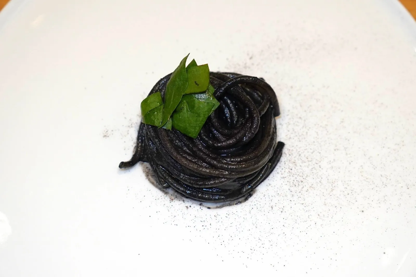 Spaghetti, smoked cuttlefish ink sauce and wood sorrelพาสต้าเส้นสปาเก็ตตี้เสิร์ฟมากับซอสหมึกดำรมควันหอมกรุ่น ด้านบนคือใบ Wood Sorrel ให้ความฉุนและอโรม่าเฉพาะตัว นอกจากนี้เชฟยังโรยผงที่เตรียมมาจาก Black Lemon ซึ่งผ่านกระบวนการจนไหม้เพื่อจะนำมาทำเป็นผงนั่นเอง (16/20)