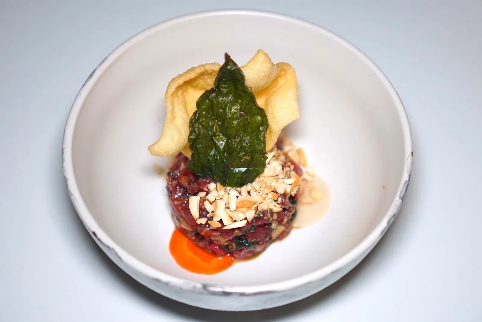 'Bo La Lot Beef Tartare (300++)premium black onyx beef, our spin on our favorite vietnamese street foodเนื้อวัวสับละเอียดเป็นทาทาร์โดยมีความหอมของเครื่องเทศและใบชะพลูสไตล์เวียดนามใต้อยู่ด้วย ด้านบนท็อปด้วยถั่วบดและข้าวเกรียบกรอบ (14/20)