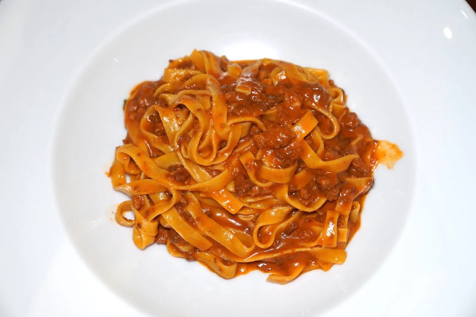 Tagliatelle con Ragú alla Bolognese (390++)Homemade Tagliatelle, slowly braised meat sauce according to the original recipeพาสต้าเส้น Tagliatelle โฮมเมดคลุกเคล้ามากับซอสเนื้อตุ๋นสูตรต้นตำรับอันเป็นเมนูเลื่องชื่อของภูมิภาค Emilia-Romagna ให้รสชาติที่เข้มข้นพอเหมาะโดยไม่หนักท้องจนเกินไป (14/20)