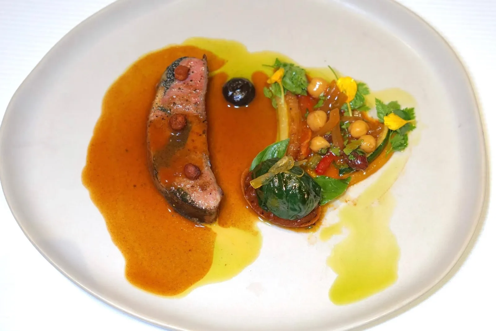 L'agneauLamb Saddle | Vegetable Tagine | Lamb Jus with Argan oilเนื้อแกะจากฟาร์มในแถบเทือกเขา Pyrenees ทางตอนใต้ของประเทศฝรั่งเศส เชฟเลือกใช้ส่วน Saddle หรือบริเวณหลังสอดไส้มูสแกะและทรัฟเฟิลดำ เชฟนำไปอบแล้วเซียต่อจนสุกกำลังดี ด้านบนท็อปด้วยถั่วลูกไก่กรอบ ๆ ไฮไลท์คือซอสจูแกะที่มีส่วนผสมของน้ำมันอาร์แกนซึ่งผสมผสานกับซอสทาร์จีนที่เตรียมมาจากผักหลายชนิดรวมไปถึง Coulis สีดำรสชาติเข้มข้นได้อย่างกลมกล่อม องค์ประกอบอื่น ๆ คือทาร์ตควินัวจับคู่กับผักปวยเล้งยัดไว้มูสแกะอบท็อปด้วยผิวมะนาวนิ้วมือกงฟี อีกฝั่งคือทาร์จีนแบบเปิดเสิร์ฟมาเป็นผักเรียงกันหลายชั้น (17/20)