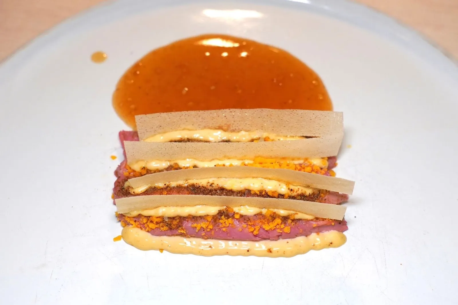 VITELLO “TONNÉ” (30 €)จานนี้เชฟนำเสนอเมนูท้องถิ่นของนคร Turin โดยไม่มีปลาทูน่าเป็นองค์ประกอบแต่เปลี่ยนมาเปนปลาแอนโชวี่แทน ด้านบนคือครัมเบิ้ลไข่แดง แผ่นแครกเกอร์ขาวเตรียมมาจากแป้งและน้ำเปล่าเท่านั้นช่วยสร้างมิติความกรอบ จากนั้นราดด้วยซอสรสชาติกลมกล่อมที่ใช้ระยะเวลาในการเตรียมนานกว่า 10 ชั่วโมง (15/20)