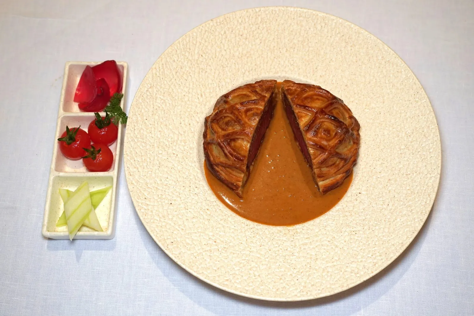 Beef Wellington (Add On 1,800++)Massaman Curryเมนูพิเศษที่ต้องสั่งจองมาล่วงหน้าคือ Beef Wellington ที่เชฟปรับรูปแบบการเสิร์ฟโดยผสมผสานวัฒนธรรมอาหารฝรั่งเศสเข้ากันกับความร่วมสมัยของอาหารไทยได้อย่างลงตัว เชฟเลือกใช้เนื้อวัวไทยสายพันธุ์ผสมระหว่างชาร์โรเล่ส์และวากิวส่วนเทนเดอร์ลอยน์ ชั้นถัดมาคือเลเยอร์ของเครื่องแกงมัสมั่นผัด ชั้นนอกสุดคือแป้งพัฟแพสทรี่บางกรอบ จากนั้นราดด้วยซอสแกงมัสมั่นเข้มข้น เชฟเสิร์ฟมากับแตงกวาดอง มะเขือเทศดอง และหอมแดงดอง