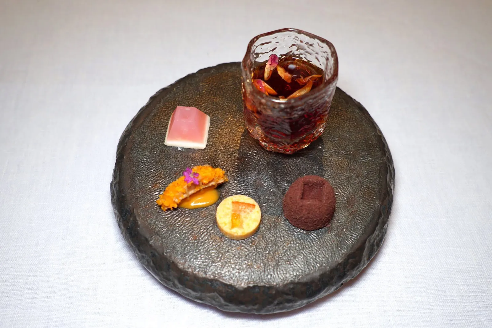 Petit FourJelly Yogurt Lychee | Bueng Salted York CustardThong-Sa-Nae with Bangmod Orange | Thai Chocolate Truffle Ballปิดท้ายด้วยขนมกาแฟประกอบไปด้วยเจลลี่โยเกิร์ตวัวแดงผสมลิ้นจี่ ส้มถัดมาคือขนมเบื้องกระฉีกและคัสตาร์ดไข่เค็ม ขนมทองเสน่ห์ใส่ส้มบางมดแห้ง สุดท้ายคือทรัฟเฟิลช็อกโกแลตไทยจากจังหวัดประจวบคีรีขันธ์ ทั้งหมดเสิร์ฟมากับชาไทยใส่อโรมาหอม ๆ ของวานิลลาและน้ำมันกุหลาบ