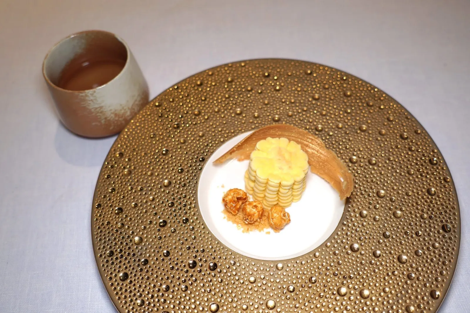 Thong-Su-WaanThong-Su-Waan Corn | Butter Scotch | Hair's Corn Teaของหวานจานนี้เชฟเลือกใช้หลายส่วนของข้าวโพดไร่สุวรรณซึ่งมีความเกี่ยวข้องกันกับสายตระกูลของเชฟโดยตรง องค์ประกอบแรกคือไอศกรีมที่เตรียมมาจากนมข้าวโพดหอมมัน ด้านในคือซุปข้าวโพดแข็งที่เตรียมมาจากเนื้อข้าวโพด รอบ ๆ คือเมล็ดข้าวโพดเตรียมมาเป็นป๊อปคอร์นกรอบ ยังมีเปลือกข้าวโพดที่เชฟใช้เป็นแบบพิมพ์ให้กับบัตเตอร์สก๊อตช์ สุดท้ายคือชาซังข้าวโพดให้รสชาติที่หวานกลมกล่อม (15/20)