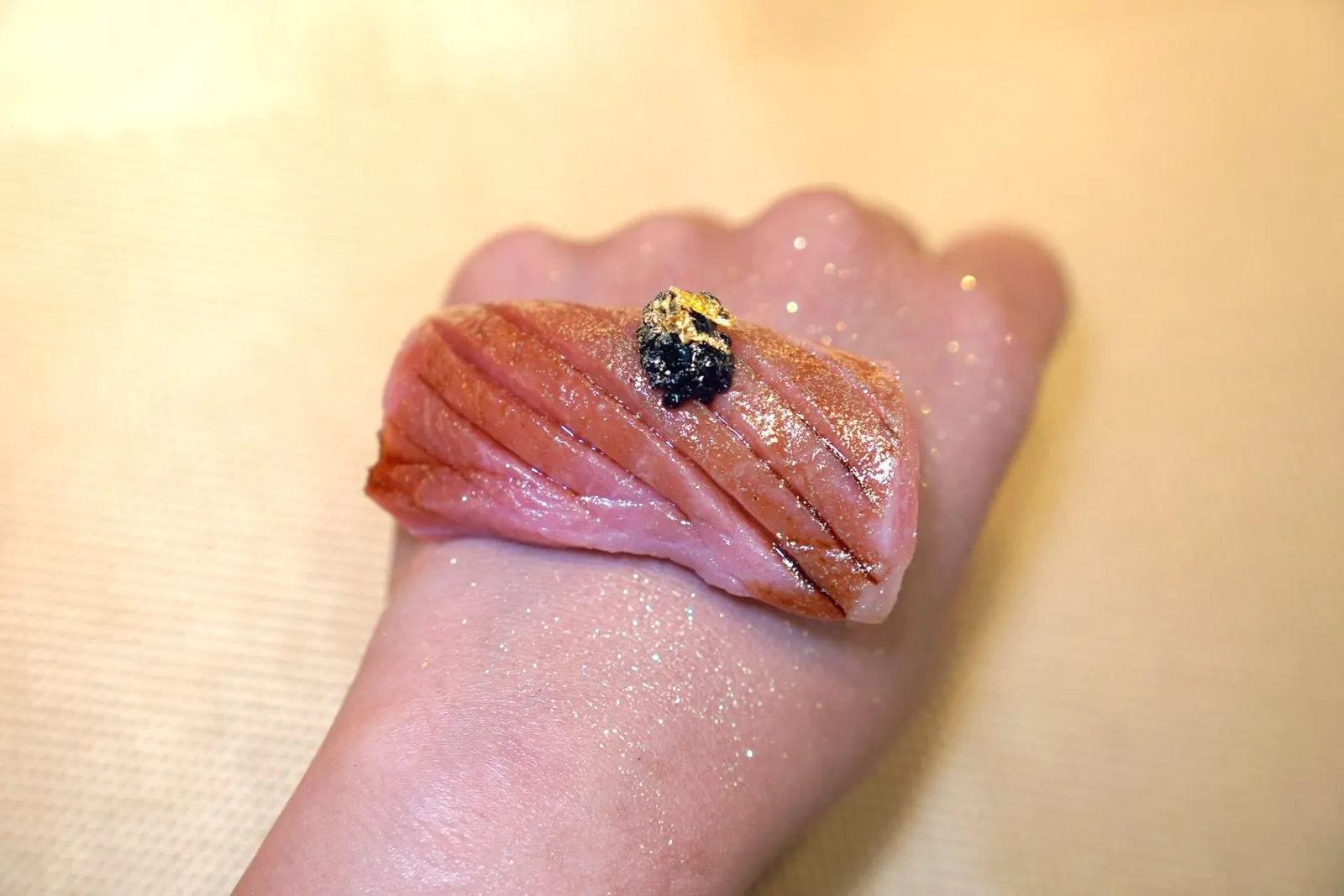 Chutoroชูโทโร่หรือส่วนท้องที่มีไขมันปานกลางเสิร์ฟมาบนหลังมือเพื่อความสนุก